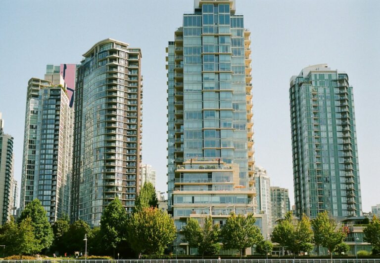 green trees near high rise buildings during daytime